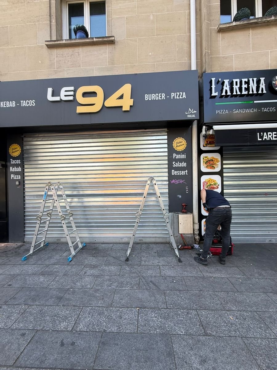 Technicien DRM Paris en intervention sur un rideau métallique de boutique