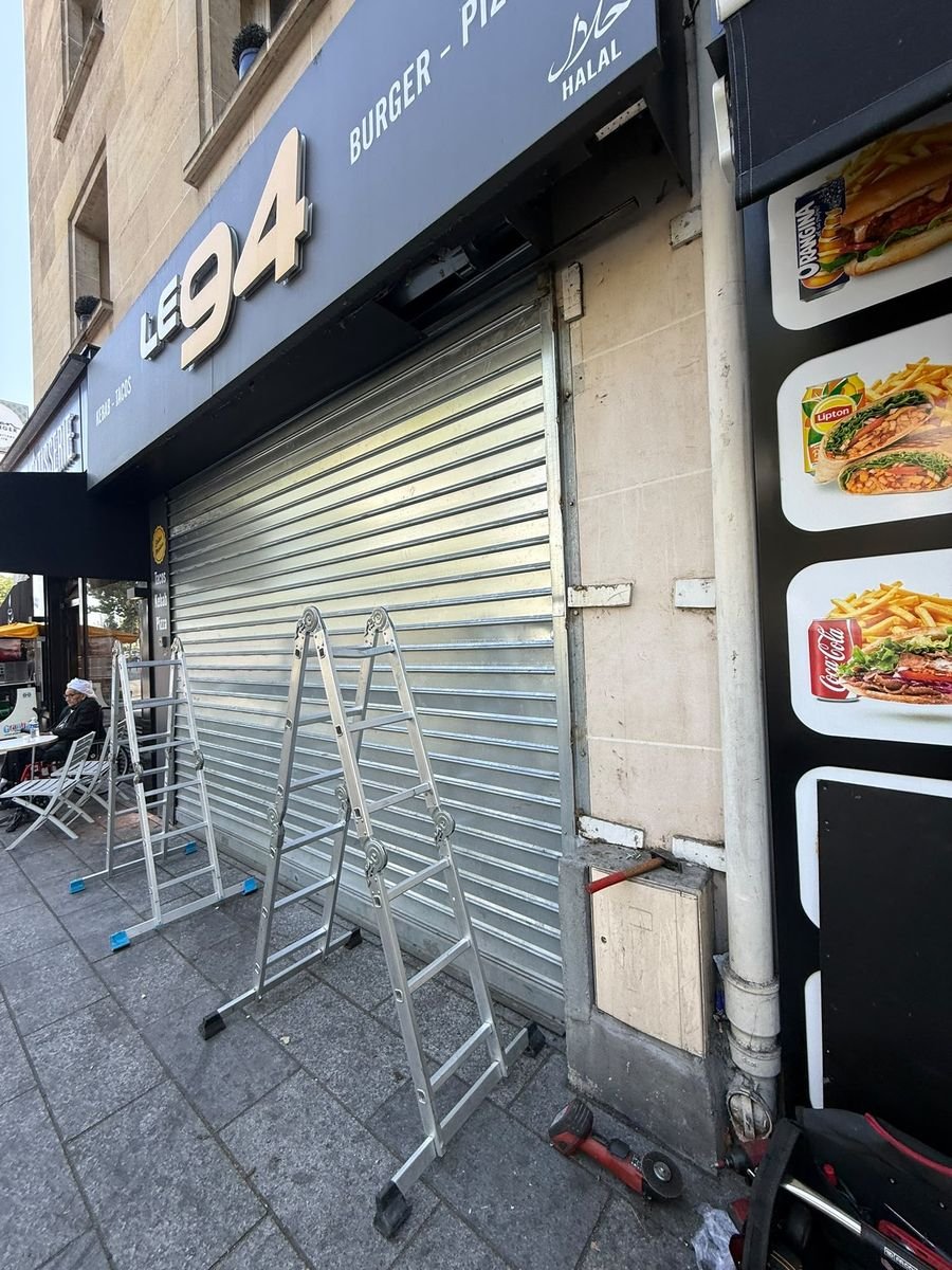 Installation d'un rideau métallique à lames pleines sur une devanture de commerce