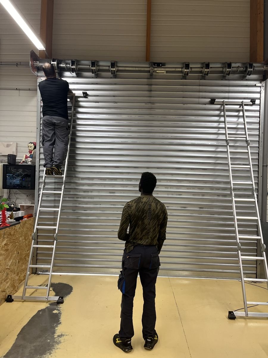 Montage d'un rideau métallique sur mesure dans notre atelier