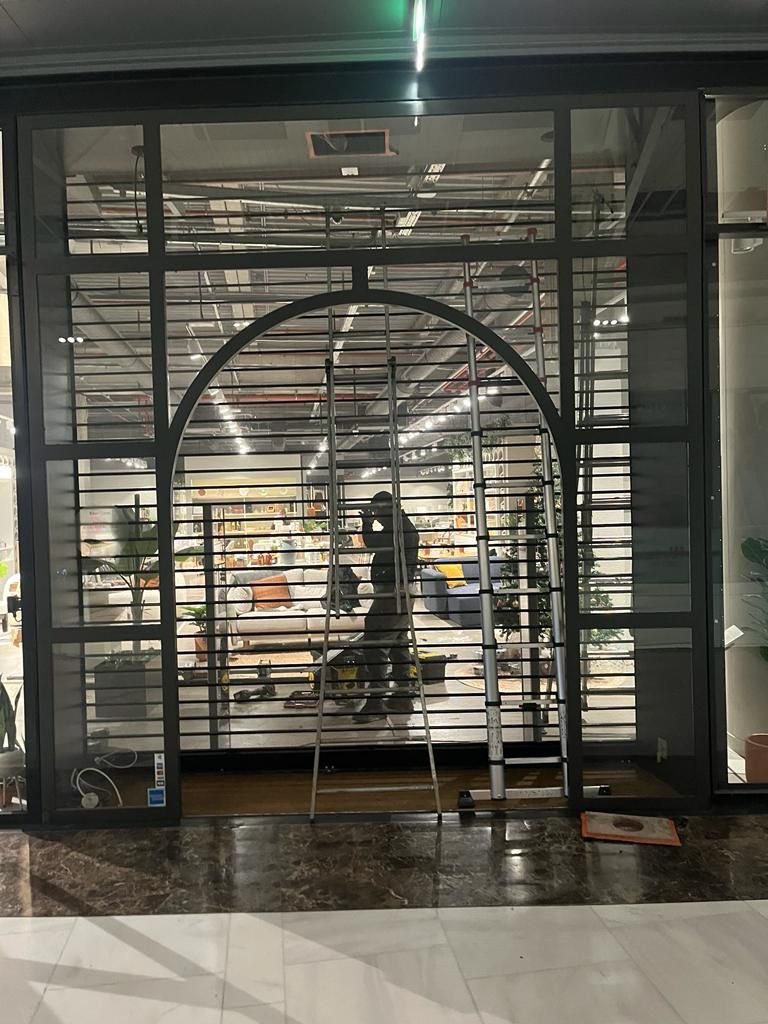 Réparation d'un rideau à tubes sur la vitrine d'un magasin